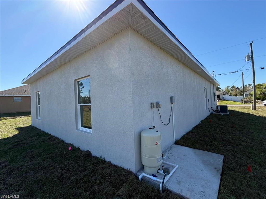 View of property exterior featuring a yard, stucco siding, and a patio