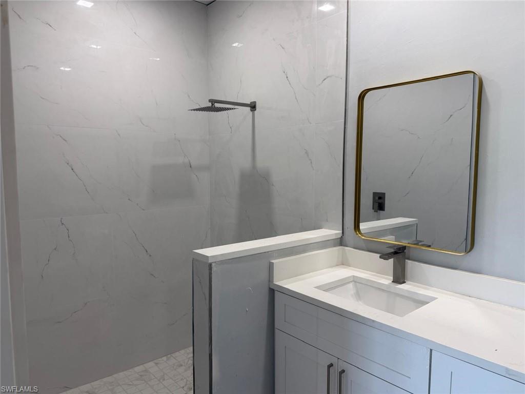 Full bathroom with vanity and a marble finish shower