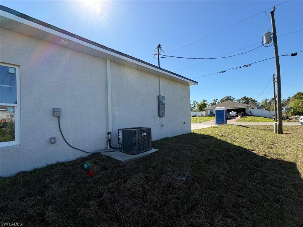 View of home's exterior with a yard and stucco siding