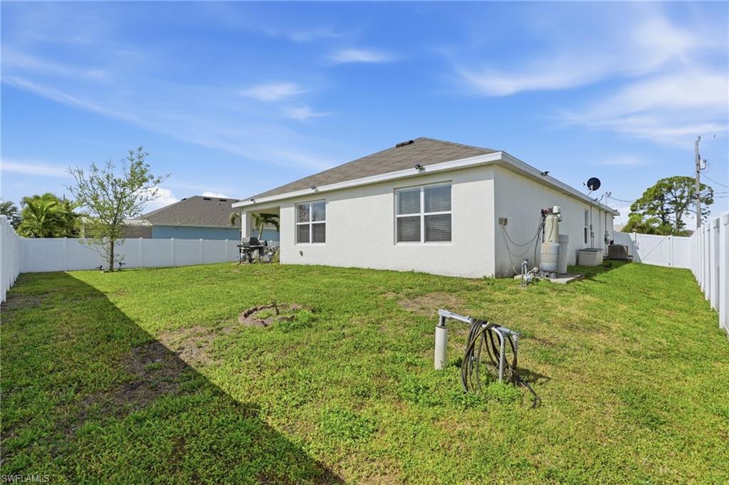 Back of house with a fenced backyard and stucco siding