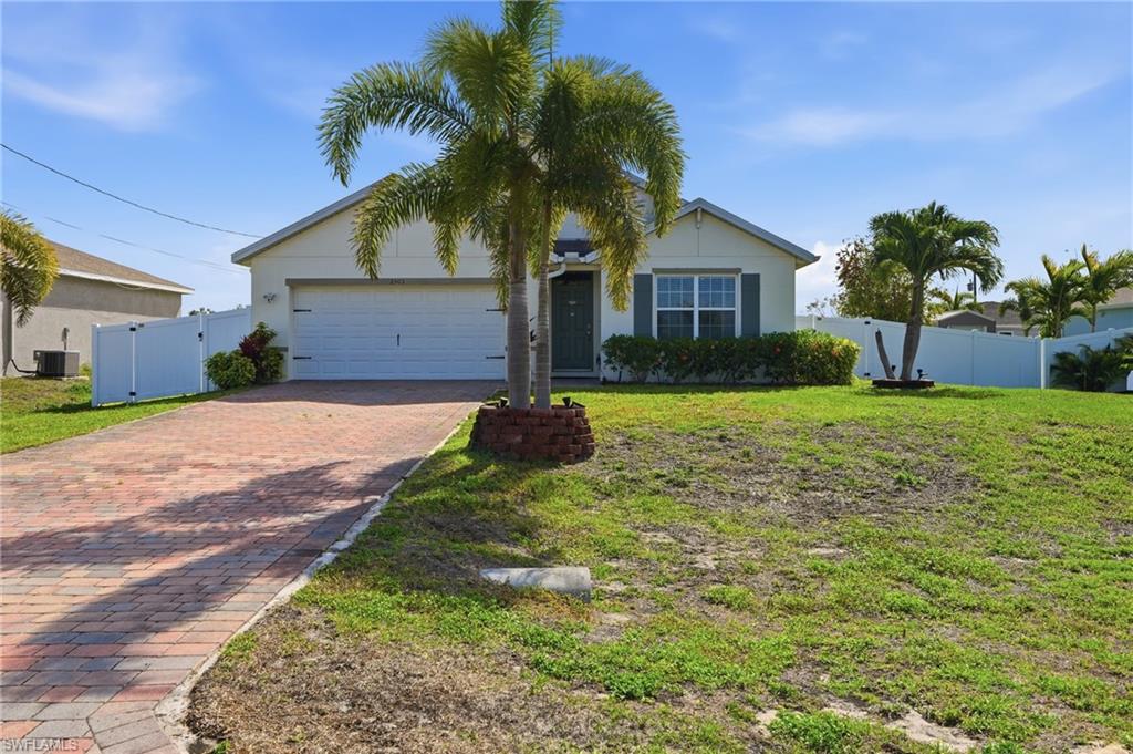 Ranch-style house with a gate, decorative driveway, a garage, and stucco siding