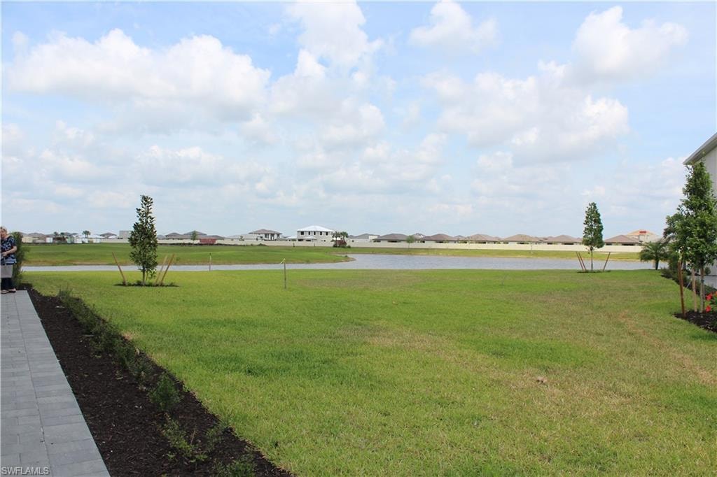 View of yard with a residential view and a water view