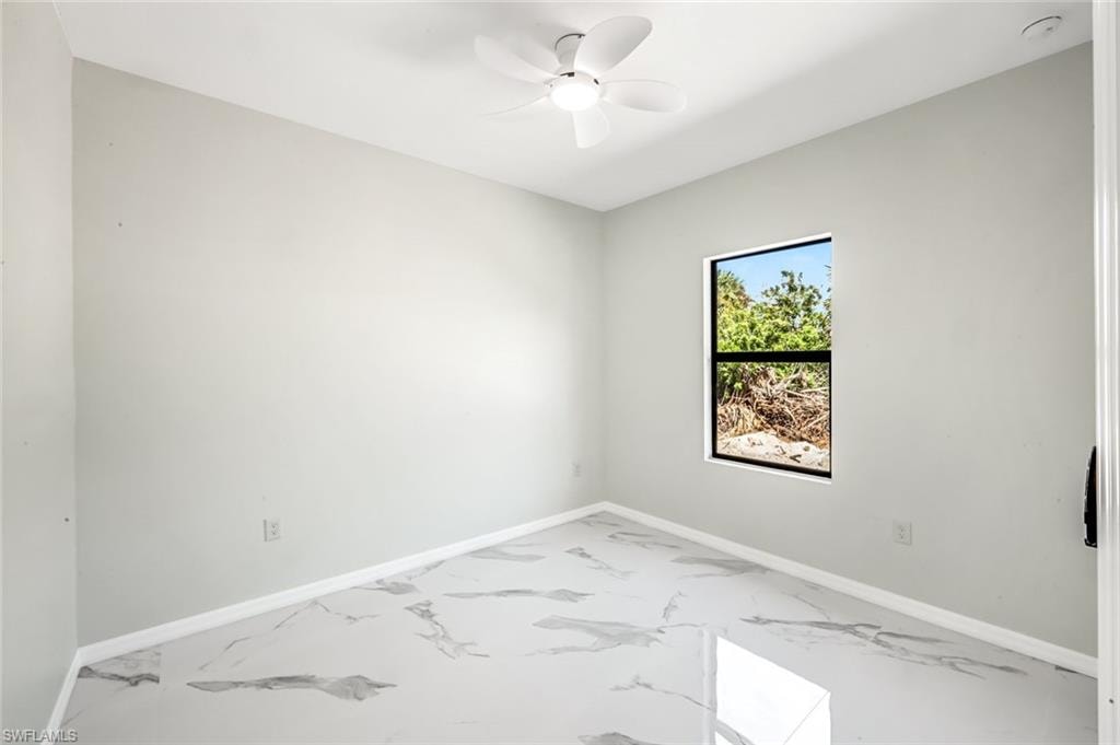 Empty room with light marble finish flooring and ceiling fan