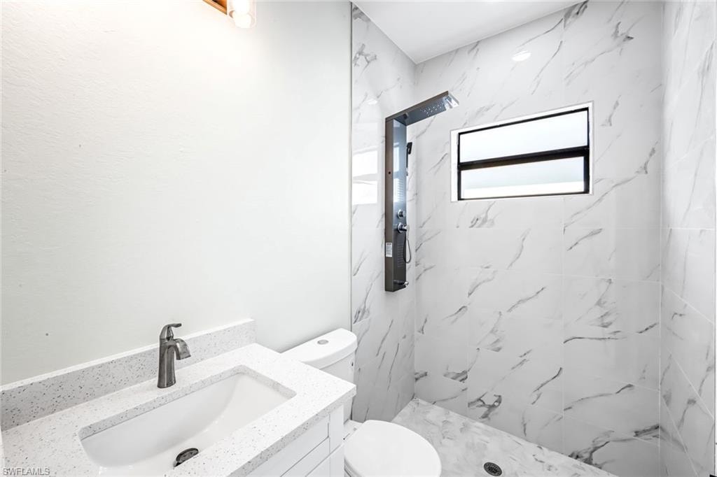 Full bath with vanity and a marble finish shower