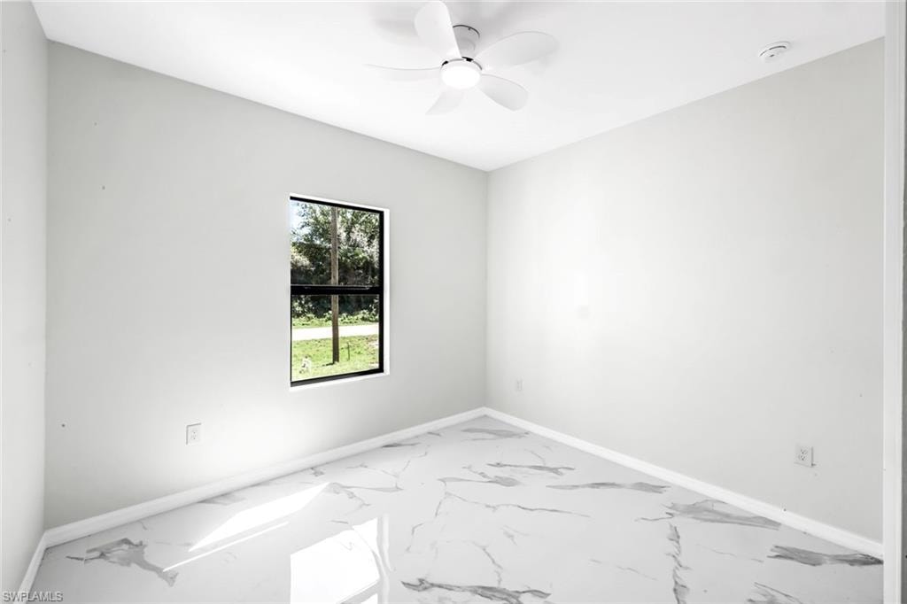 Empty room with ceiling fan and light marble finish flooring