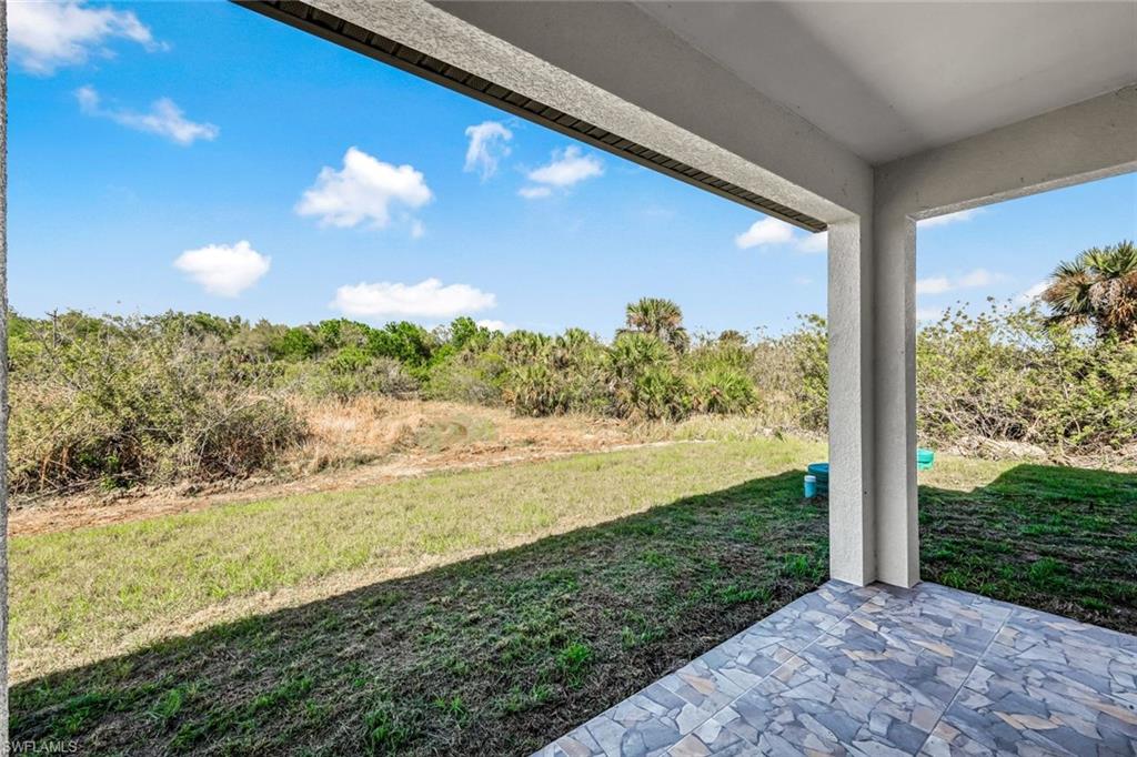 View of green lawn featuring a patio area