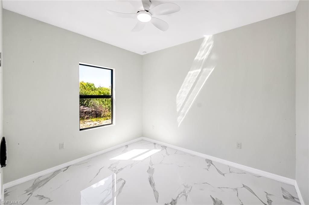 Unfurnished room with a ceiling fan and marble look tiles