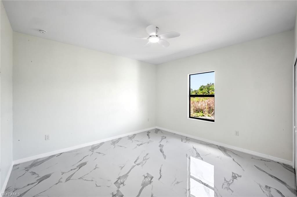 Empty room featuring baseboards and ceiling fan
