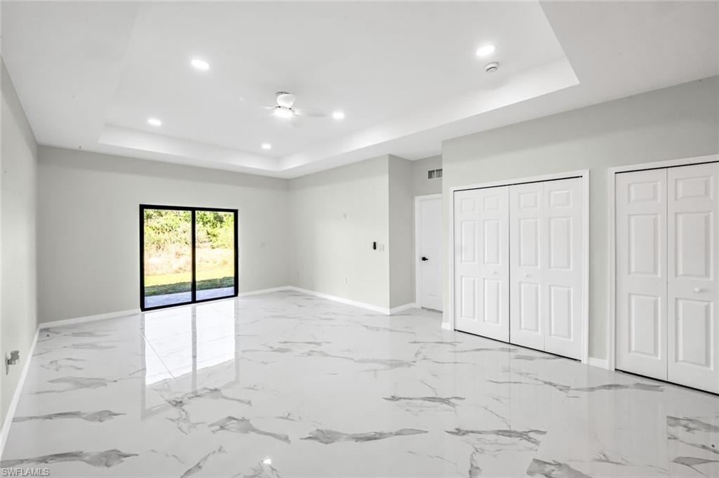 Unfurnished bedroom featuring two closets, recessed lighting, access to exterior, light marble finish flooring, and ceiling fan