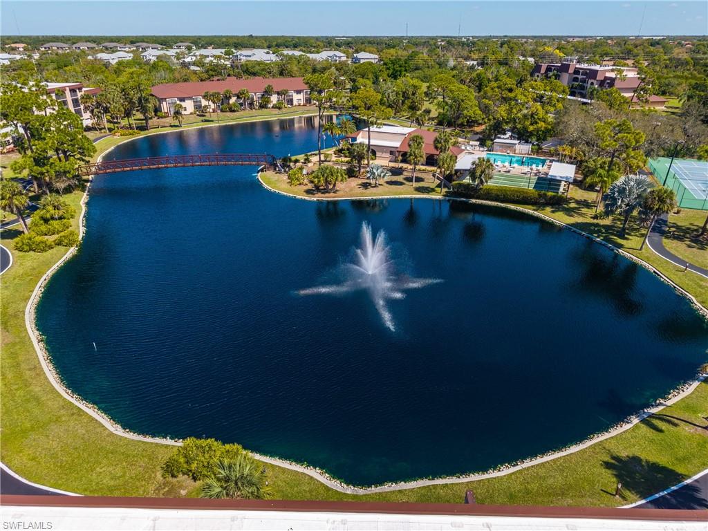 Drone / aerial view of a nearby body of water and a tree filled landscape