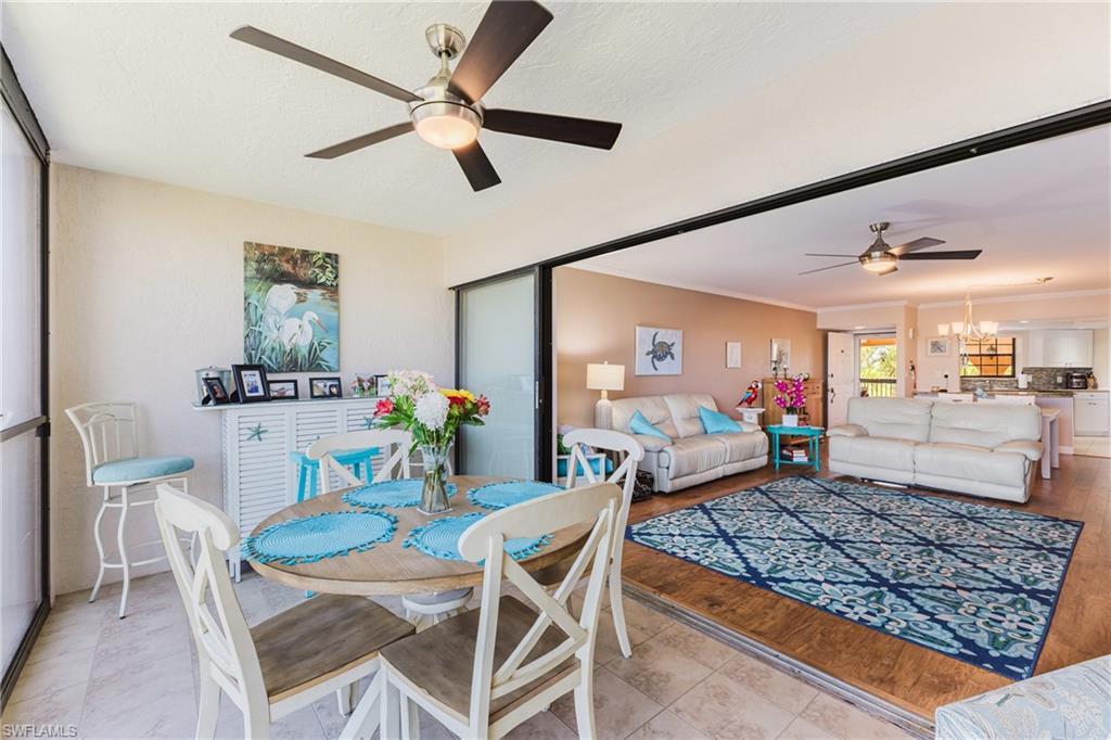 Dining space with a ceiling fan, suspended lighting, and ornamental molding