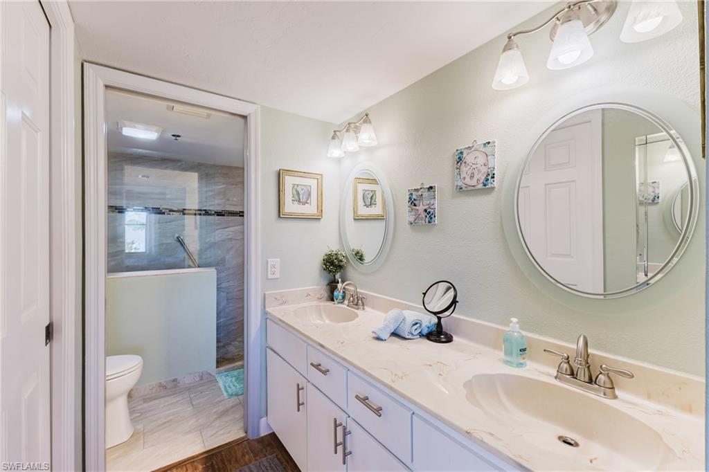 Bathroom featuring double vanity and a tile shower