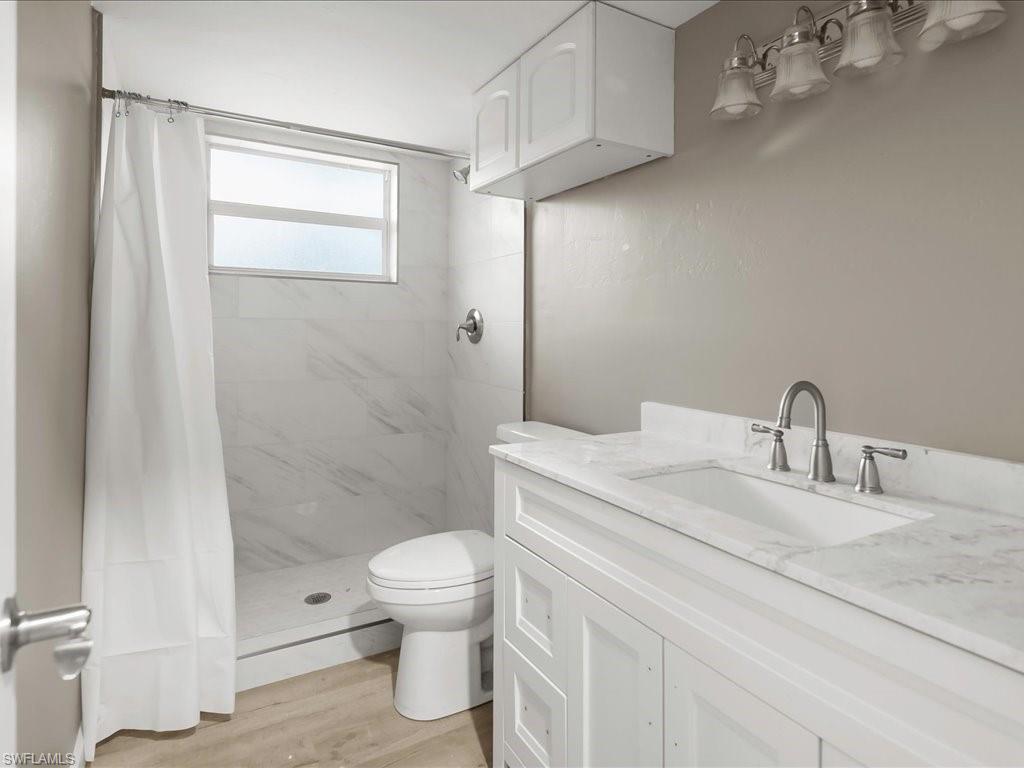 Bathroom with vanity, a stall shower, and light wood-type flooring
