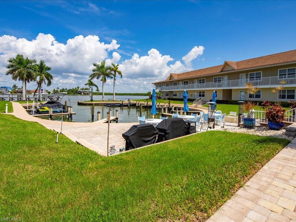 Dock with a lawn, a water view, and a patio