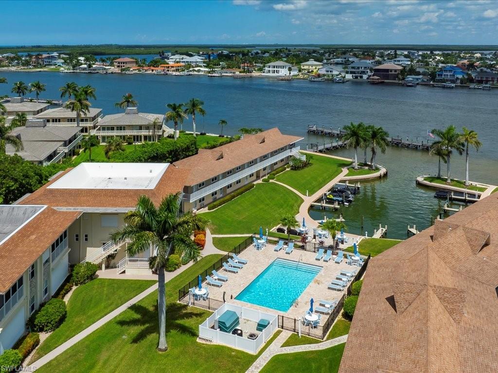 Bird's eye view of a pool area and a nearby body of water
