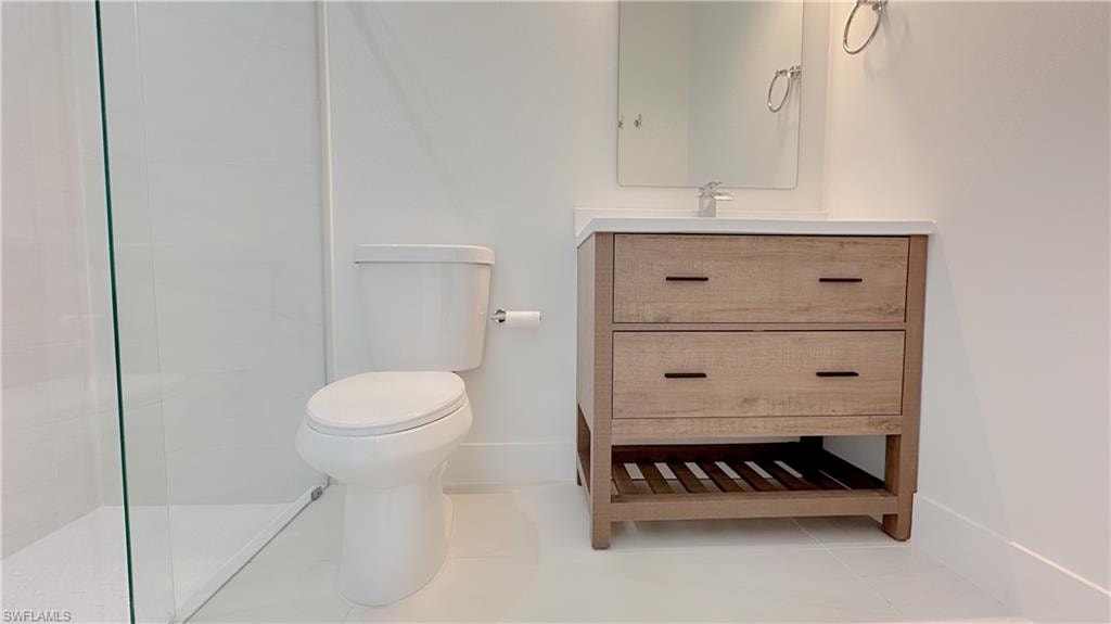 Full bathroom featuring vanity, a tile shower, and light tile patterned floors