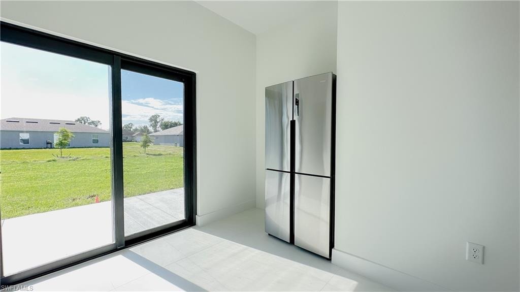 Kitchen with freestanding refrigerator and baseboards