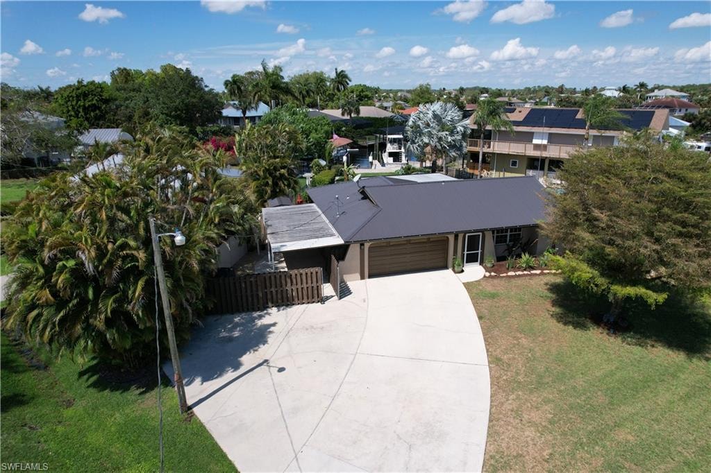 View of front of house with an attached garage, concrete driveway, and a metal roof
