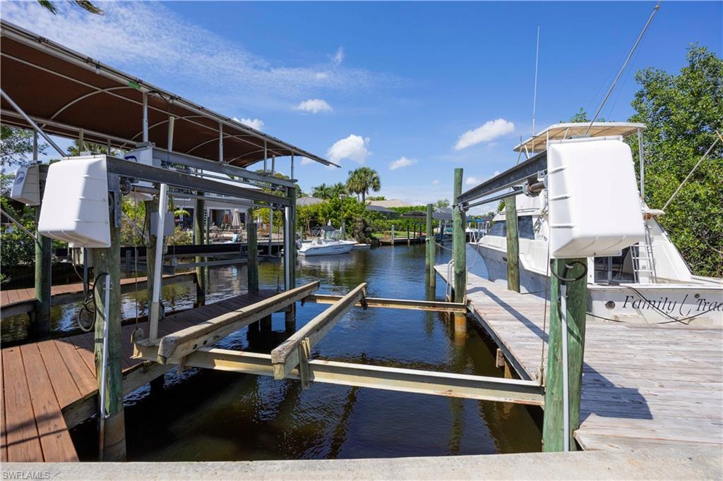 Dock featuring boat lift and a water view