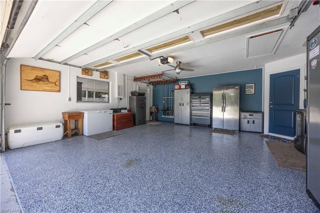Garage featuring freestanding refrigerator and ceiling fan