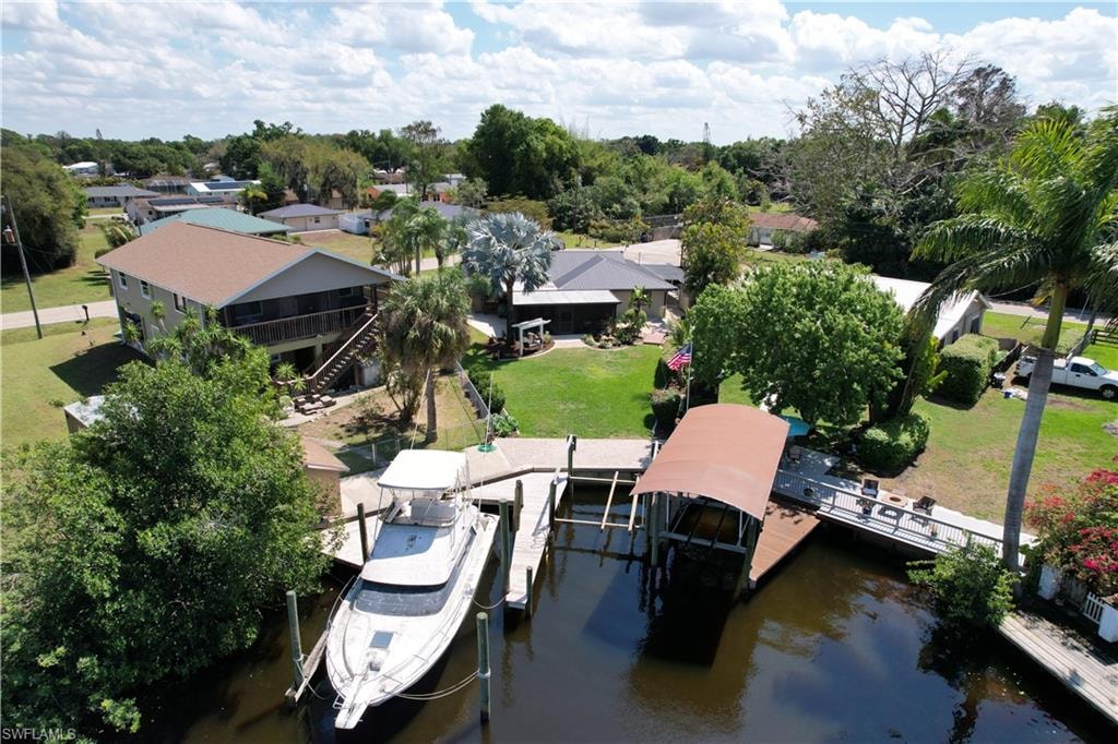Dock area featuring boat lift, a water view, a yard, and a patio area