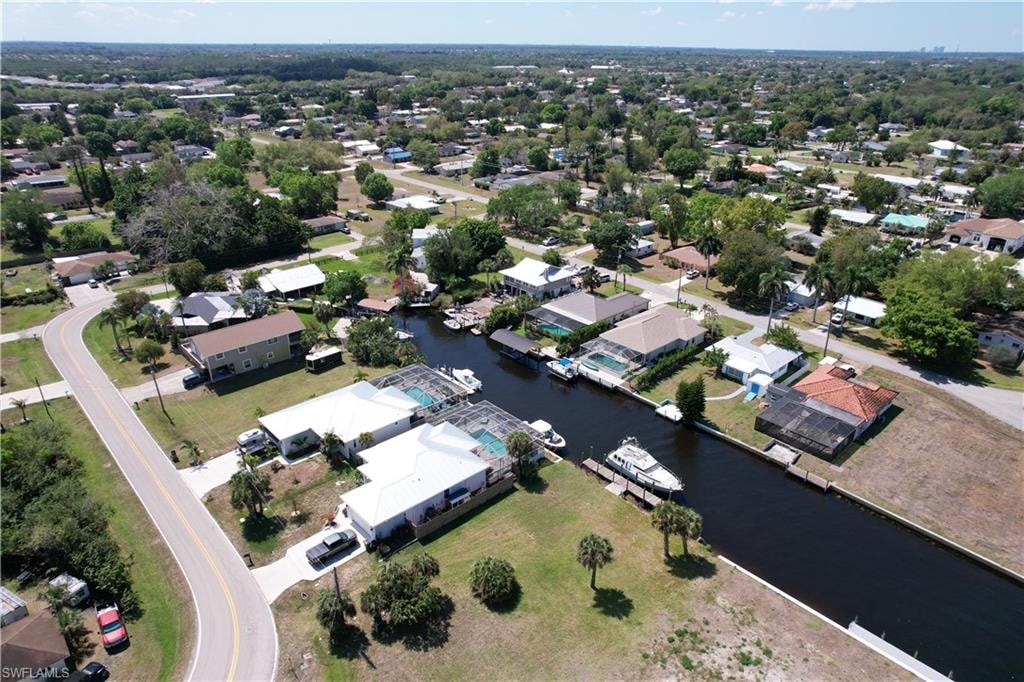 Aerial view of property and surrounding area with a nearby body of water and nearby suburban area