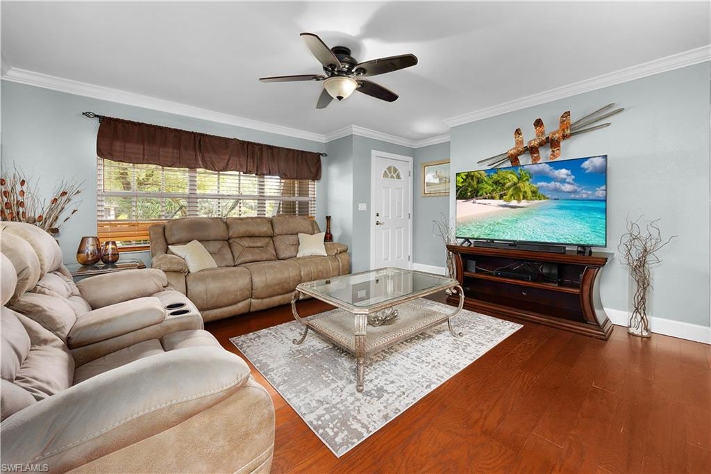 Living area with crown molding, wood finished floors, and a ceiling fan