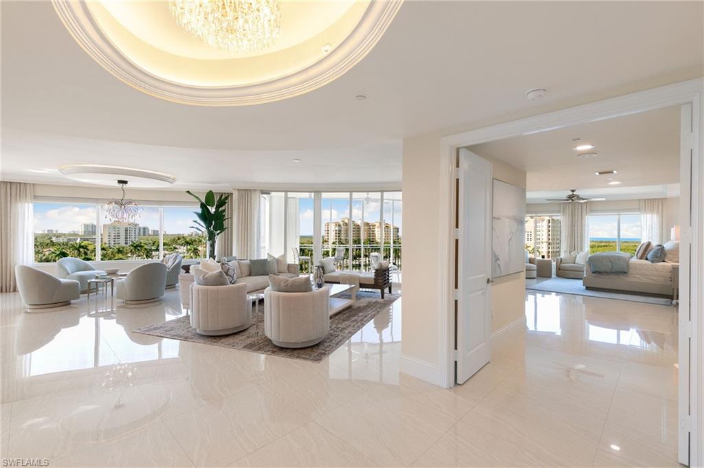 Grand Living room with porcelain floors, ornamental molding ,chandelier and built-in Fireplace with views overlooking the Gulf and Naples