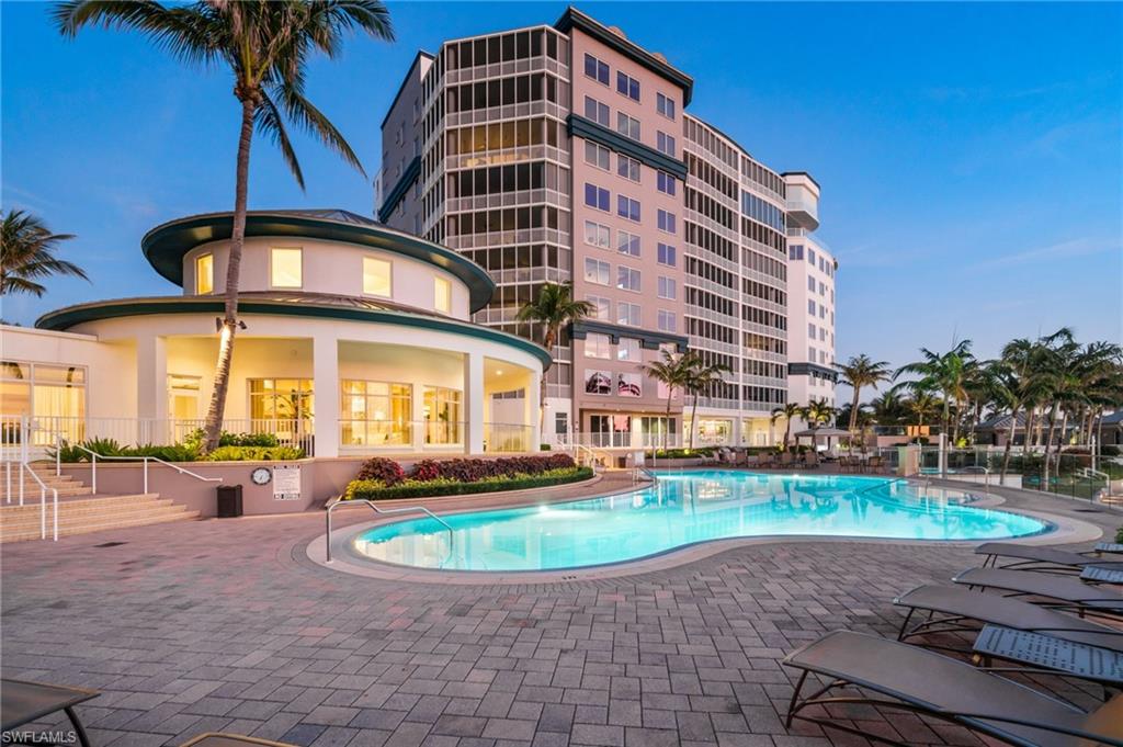 Twilight View of swimming pool featuring a patio, spa and lounging areas