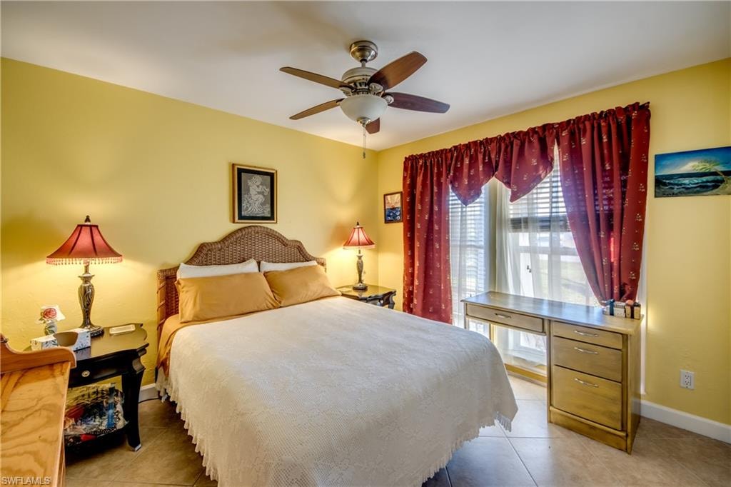 Tiled bedroom featuring ceiling fan