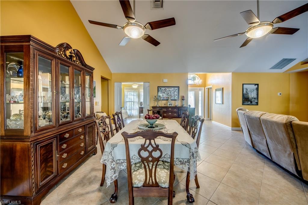 Dining space with light tile patterned floors and vaulted ceiling
