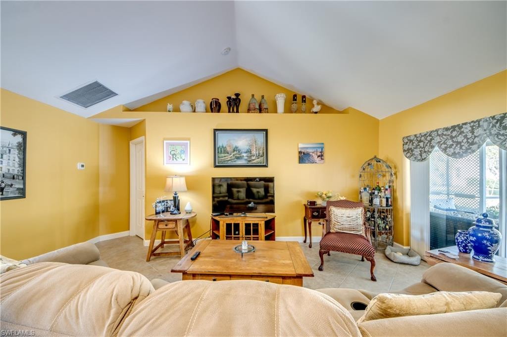 Living room with light tile patterned floors and vaulted ceiling