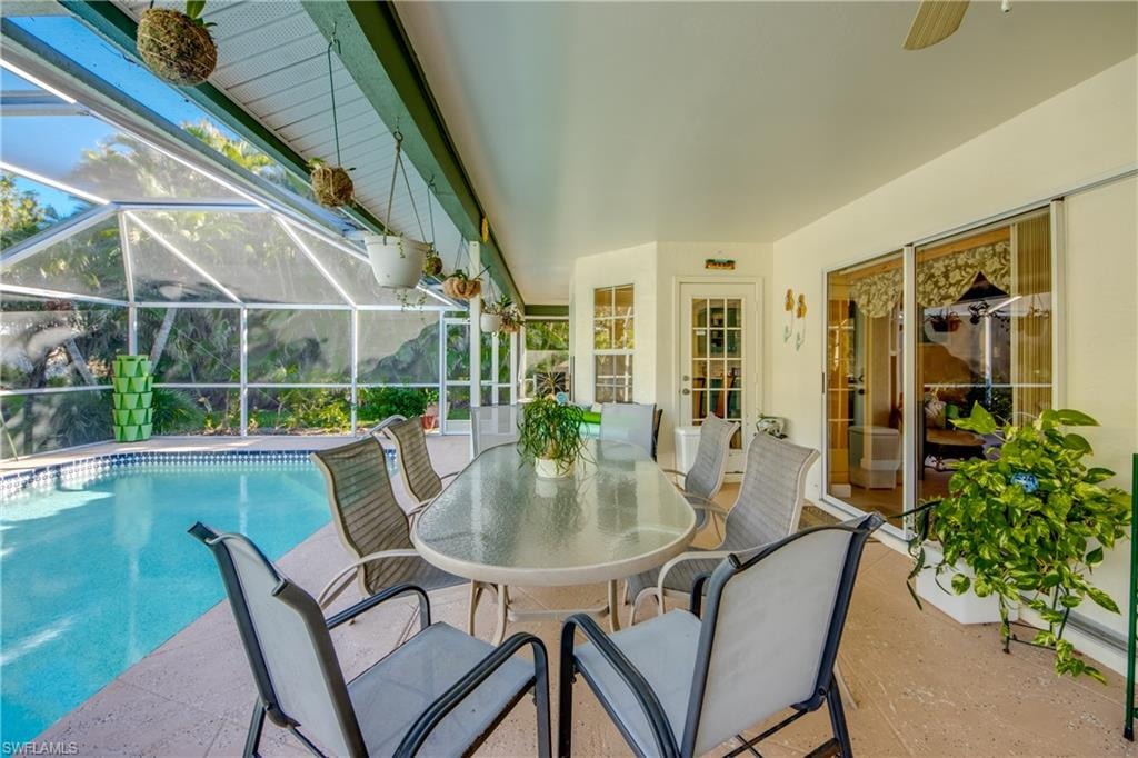 View of swimming pool featuring a lanai, a patio area, and ceiling fan