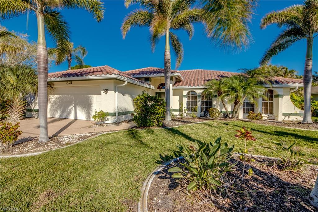 Mediterranean / spanish-style house with a garage and a front lawn