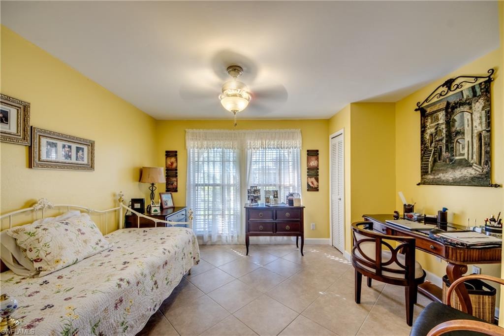 Tiled bedroom with a closet and ceiling fan