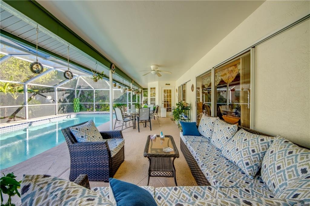 Sunroom / solarium featuring ceiling fan and a pool