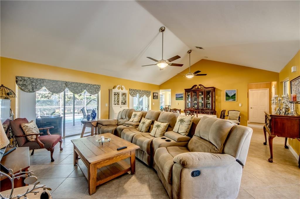 Tiled living room featuring ceiling fan and lofted ceiling