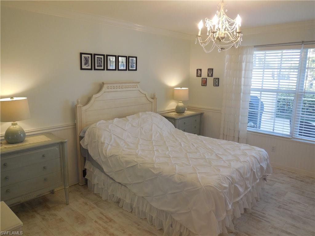 Bedroom with crown molding and a chandelier