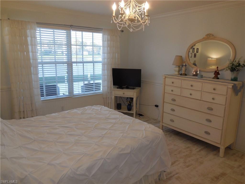 Bedroom with a notable chandelier and crown molding