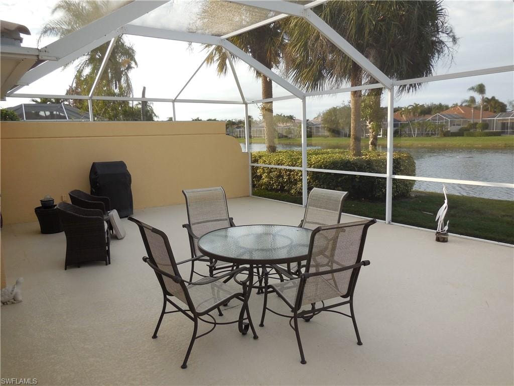 View of patio featuring a lanai and a water view