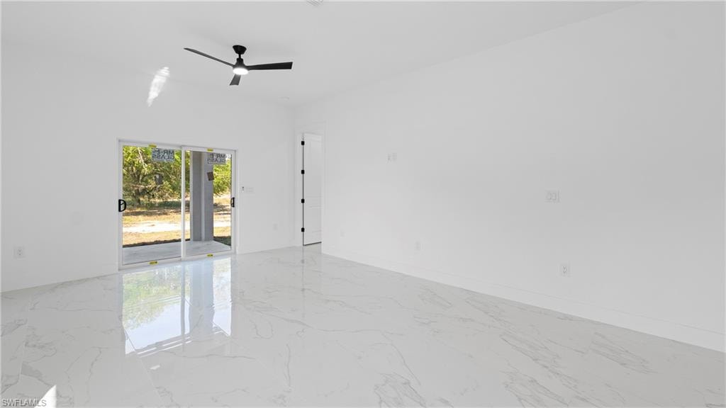 Empty room featuring ceiling fan and light marble finish flooring