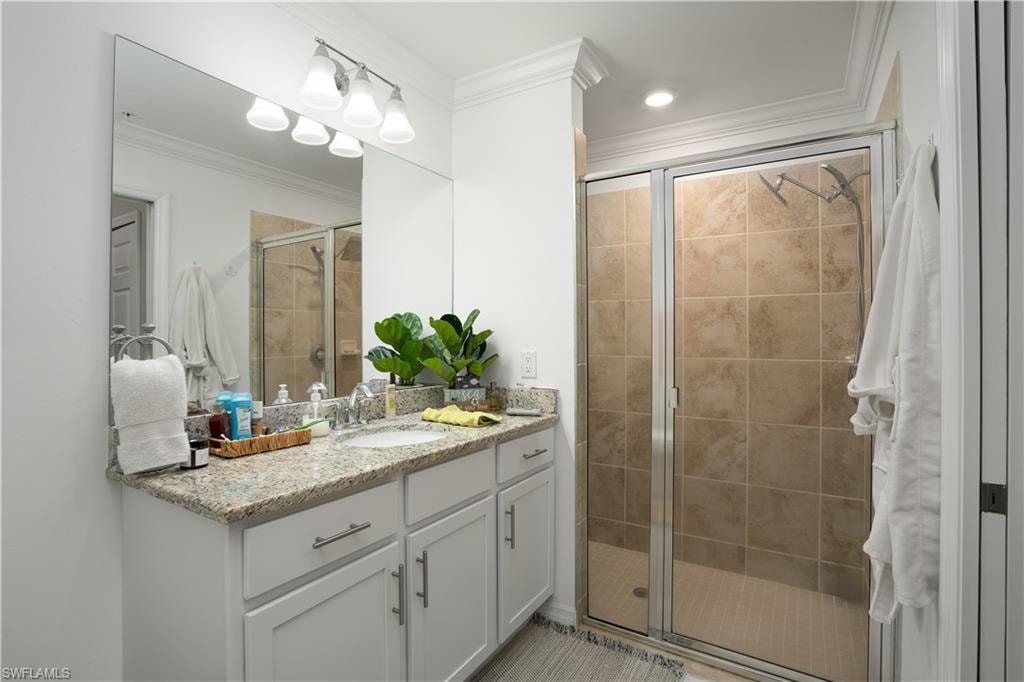 Full bath with a stall shower, vanity, and crown molding
