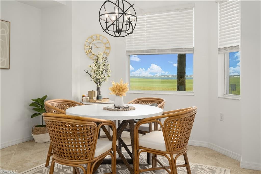Dining space with a chandelier, baseboards, and light tile patterned floors
