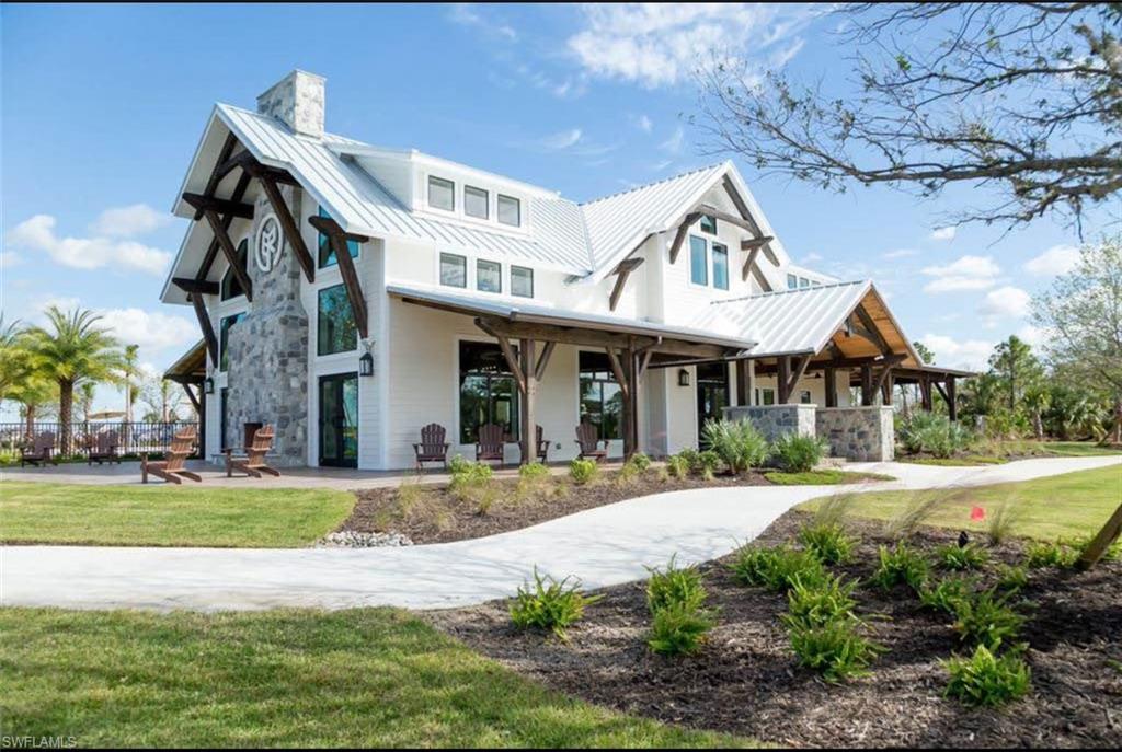 View of front of home with a chimney, a front yard, a standing seam roof, a patio area, and metal roof