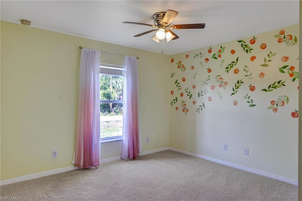 Unfurnished room featuring light carpet and ceiling fan