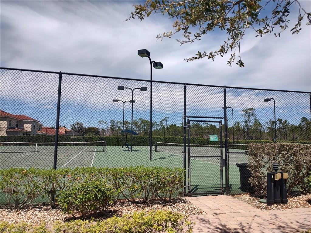 View of tennis court featuring a gate