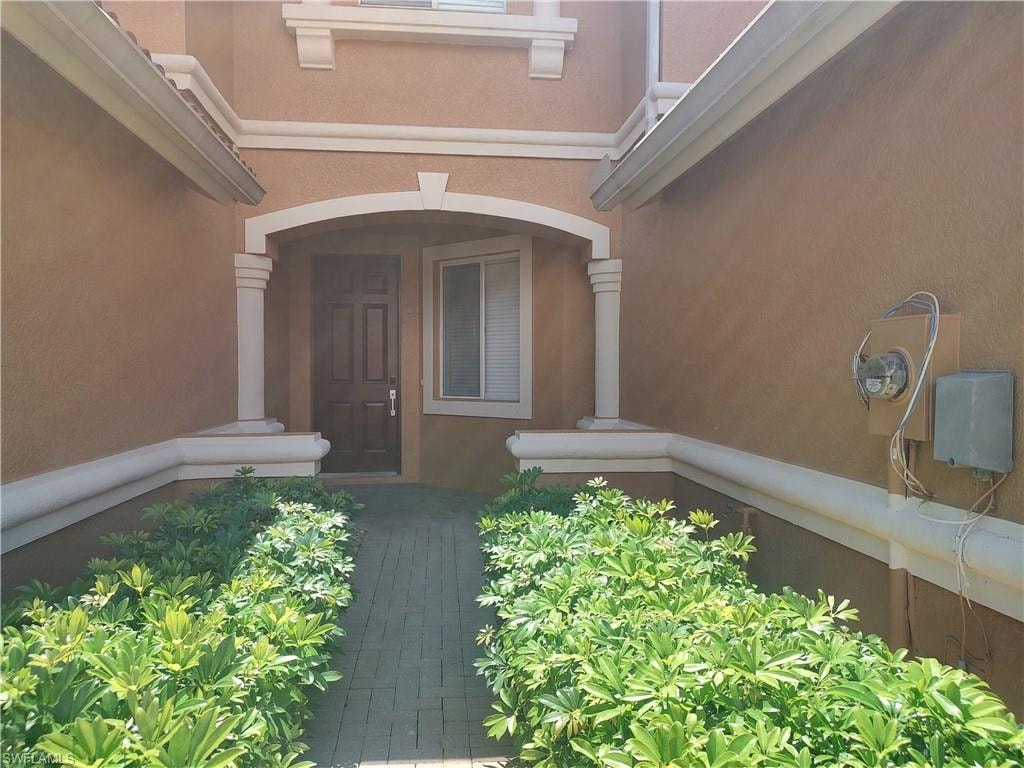 Doorway to property featuring stucco siding