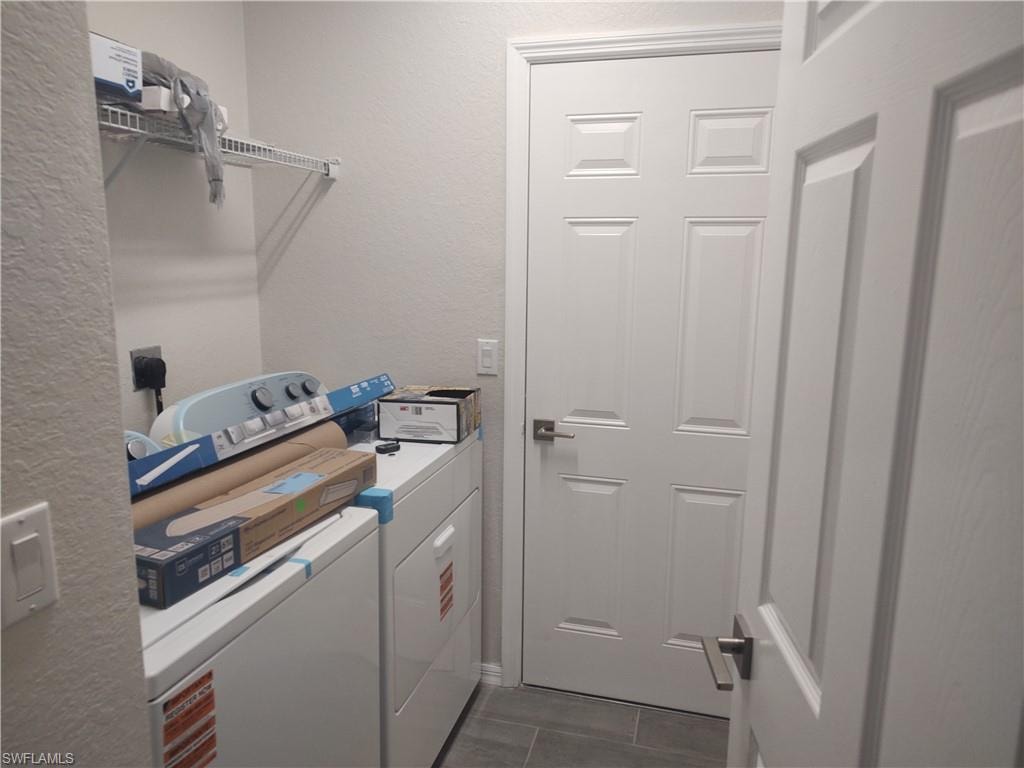 Laundry area with a textured wall and washing machine and dryer