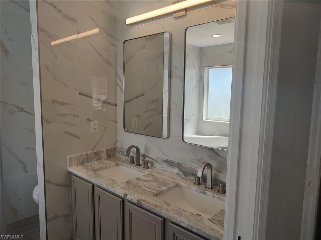 Newly remodeled bathroom with double vanity and toilet