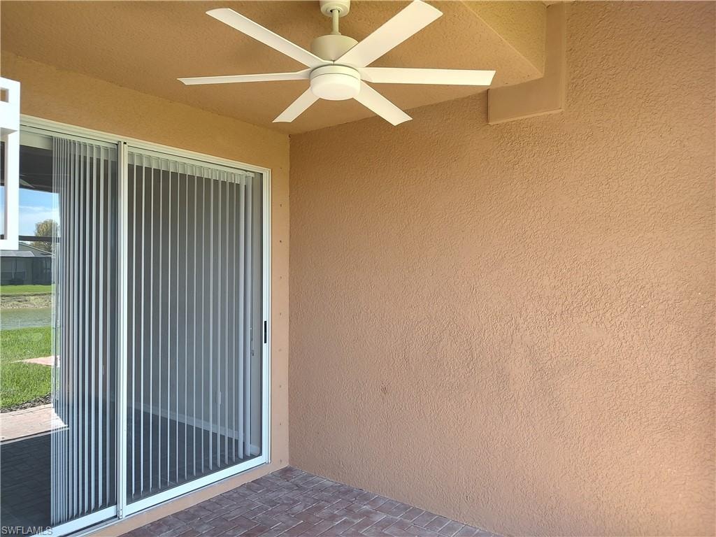 Entrance to property featuring stucco siding, a ceiling fan, and a patio area